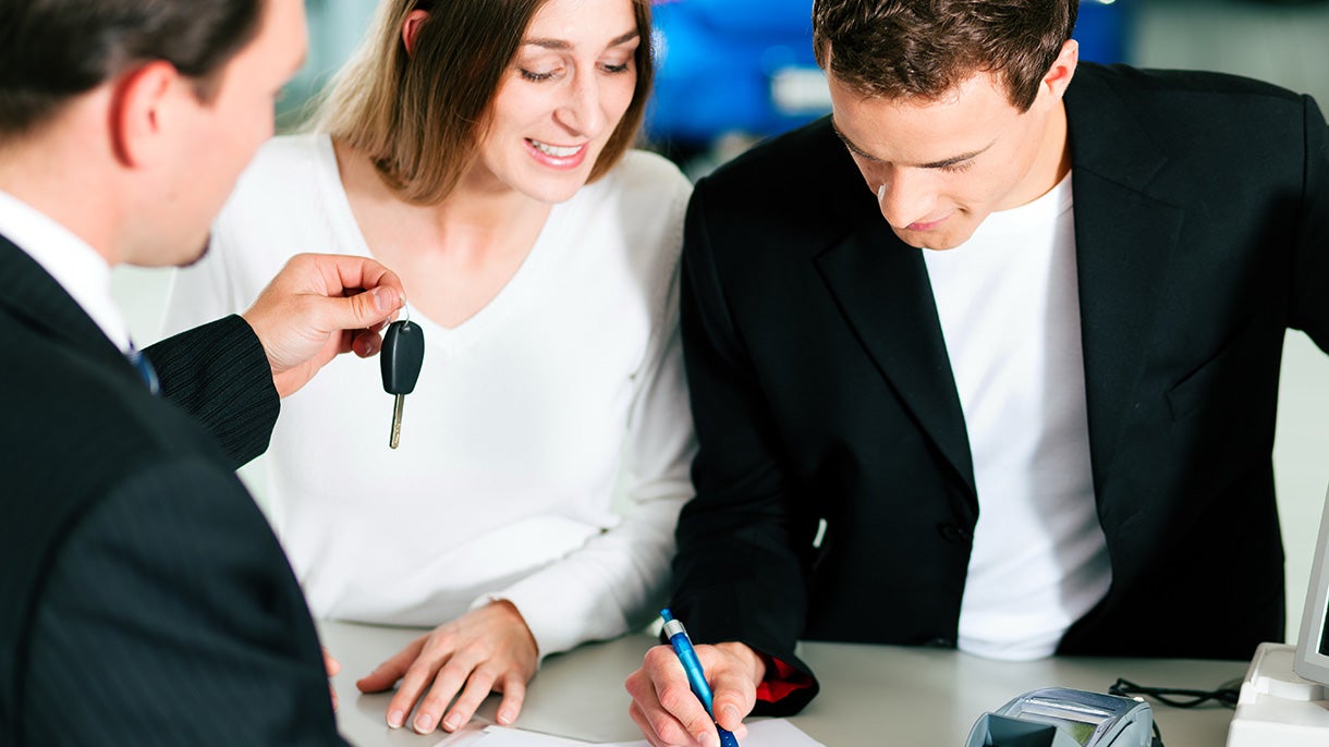 couple getting keys from salesman